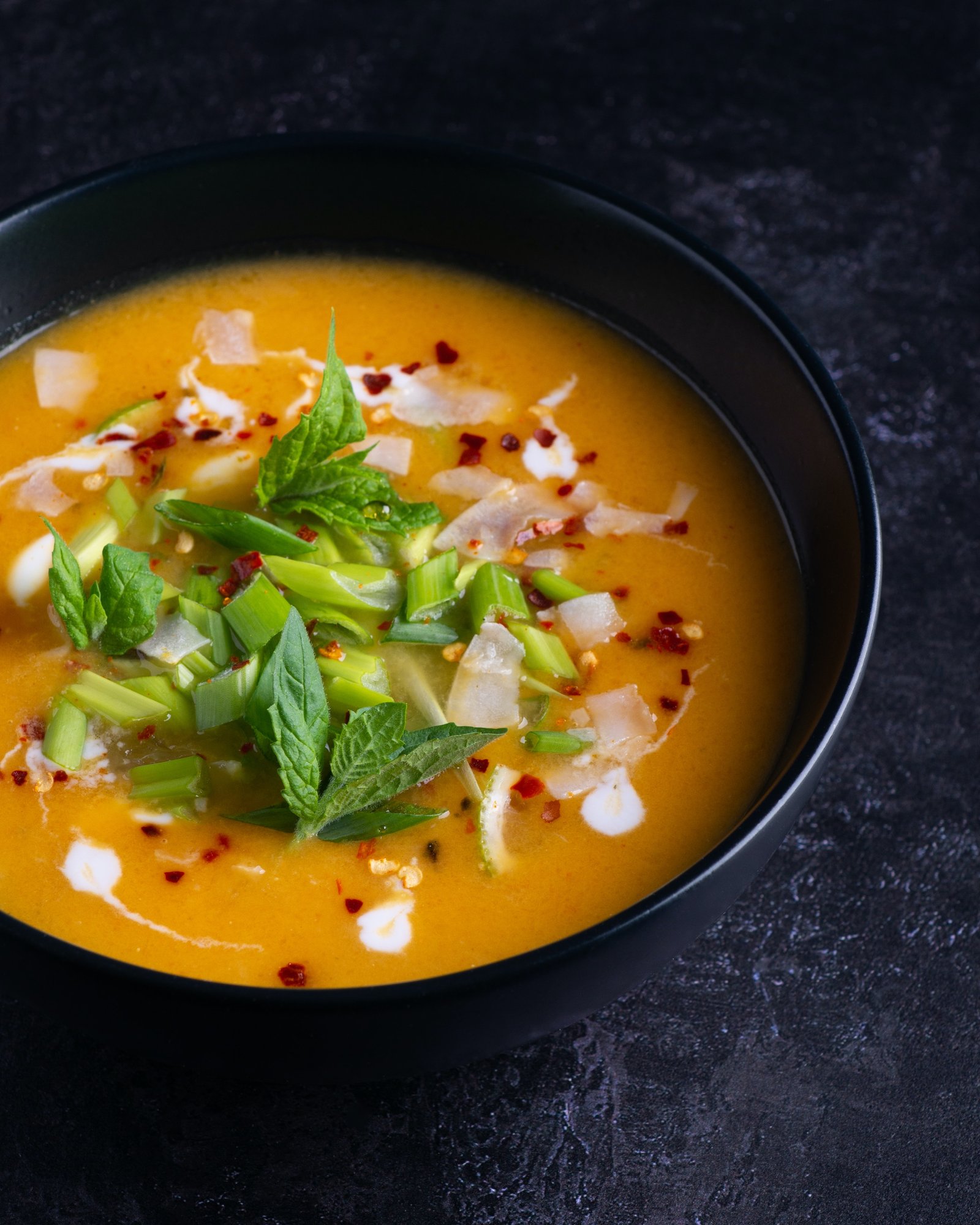 Soup With Green Leaf In Black Ceramic Bowl